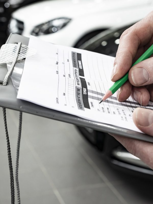 Mechanic writing to the clipboard at workshop warehouse